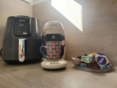 a coffee maker sitting next to a plate of food at Les Cèdres - grand studio - neuf in Castres