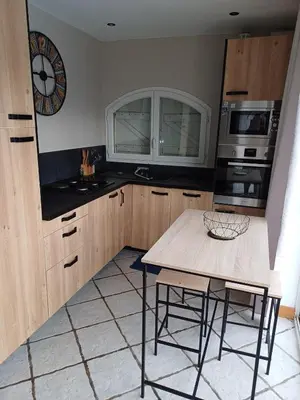 a kitchen with a table and a clock on the wall at Studio bord de mer in Port-la-Nouvelle