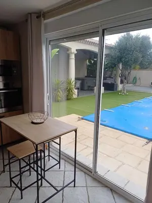 a kitchen with a table and a large sliding glass door at Studio bord de mer in Port-la-Nouvelle