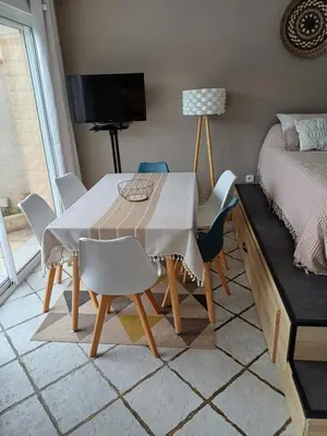 a dining room with a table and chairs and a bed at Studio bord de mer in Port-la-Nouvelle