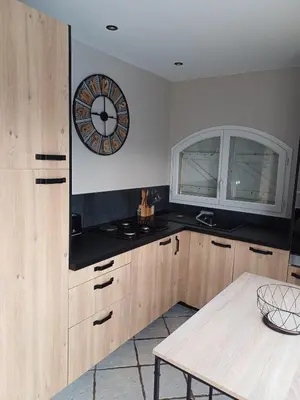 a kitchen with a clock on the wall and a table at Studio bord de mer in Port-la-Nouvelle