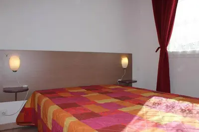 a bedroom with a bed with a colorful quilt at Appartement climatisé avec piscine - Vue Clape GN190-711 in Gruissan