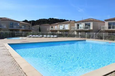 a large swimming pool in front of some apartments at Appartement climatisé avec piscine - Vue Clape GN190-711 in Gruissan
