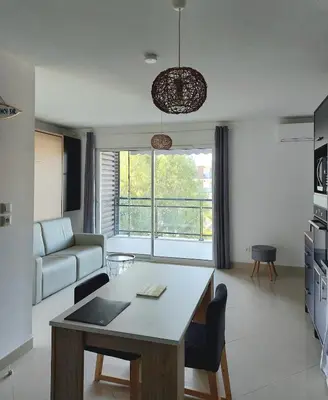a living room with a table and a couch at Grand Studio à 300m de la plage dans Résidence calme - une seule pièce in Gruissan
