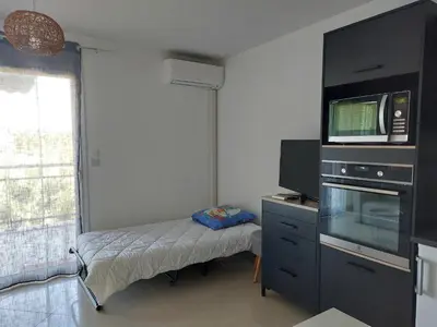 a small room with a small bed and a television at Grand Studio à 300m de la plage dans Résidence calme - une seule pièce in Gruissan