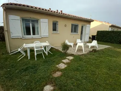 a group of white tables and chairs in front of a house at villa 2 chambres en rez-de-jardin in Puylaurens