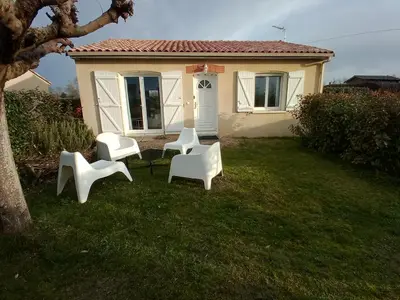 a group of white chairs in the yard of a house at villa 2 chambres en rez-de-jardin in Puylaurens