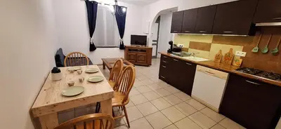 a kitchen with a wooden table and chairs in a kitchen at Charming Apartment in La Redorte in La Redorte
