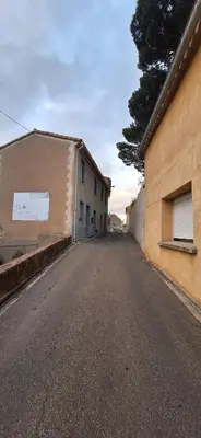 an empty street next to a building and a tree at Charming Apartment in La Redorte in La Redorte