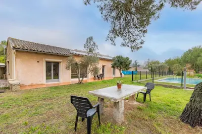 a table and chairs in the yard of a house at Le Coteau Ensoleillé - Climatisée avec piscine in Carcassonne