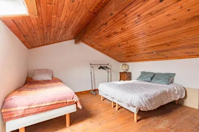 two beds in a room with a wooden ceiling at Le Coteau Ensoleillé - Climatisée avec piscine in Carcassonne