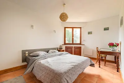 a bedroom with a bed and a table and a desk at Le Coteau Ensoleillé - Climatisée avec piscine in Carcassonne
