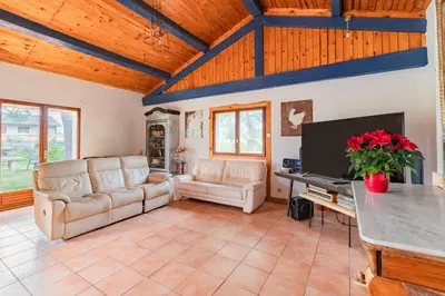 a living room with couches and a flat screen tv at Le Coteau Ensoleillé - Climatisée avec piscine in Carcassonne