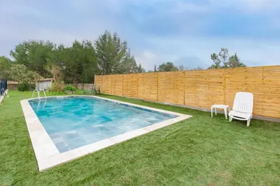 a backyard with a swimming pool and a wooden fence at Le Coteau Ensoleillé - Climatisée avec piscine in Carcassonne