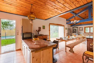 a kitchen with a wooden ceiling and a dining room at Le Coteau Ensoleillé - Climatisée avec piscine in Carcassonne
