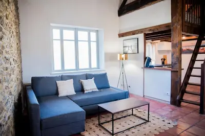 a living room with a blue couch and a table at Mezza'Cosy, apt avec parking à 2 pas de la Cité in Carcassonne