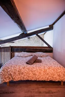a bed with a pillow and a hat on it at Mezza'Cosy, apt avec parking à 2 pas de la Cité in Carcassonne