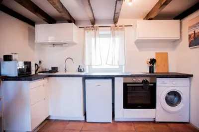 a kitchen with white cabinets and a washer and dryer at Mezza'Cosy, apt avec parking à 2 pas de la Cité in Carcassonne