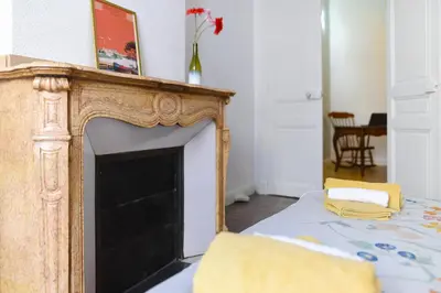 a living room with a fireplace and a bed at le RAMOND in Carcassonne