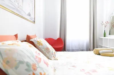 a bedroom with a bed and a red chair at le RAMOND in Carcassonne