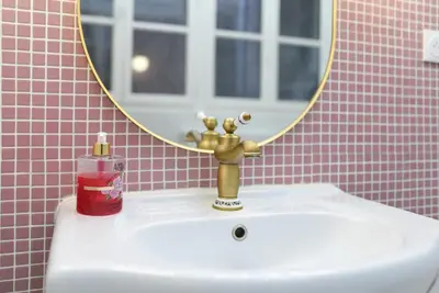 a bathroom sink with a gold faucet and a mirror at le RAMOND in Carcassonne