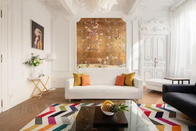 a living room with a white couch and a rug at le RAMOND in Carcassonne