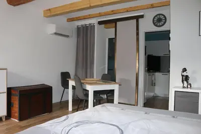 a bedroom with a bed and a desk and a table at L'Autan sage in Montgeard