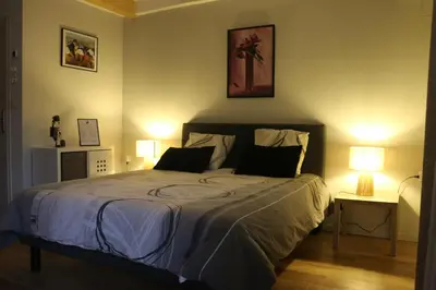 a bedroom with a large bed with two lamps at L'Autan sage in Montgeard