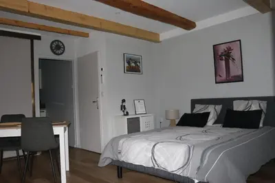 a bedroom with a bed and a desk and a clock at L'Autan sage in Montgeard
