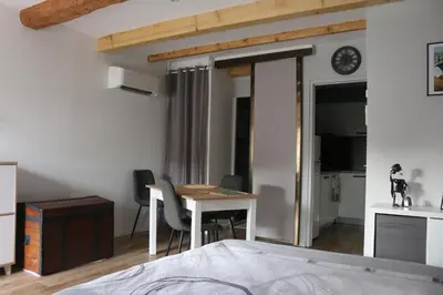 a bedroom with a bed and a table and chairs at L'Autan sage in Montgeard
