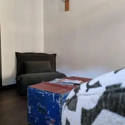 a living room with a couch and a blue trunk at La Bulle Carrée - Centre Historique médiéval - in Lapalme