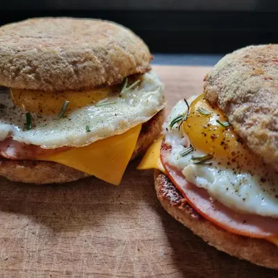 two breakfast sandwiches with eggs and cheese on a cutting board at La Bulle Carrée - Centre Historique médiéval - in Lapalme