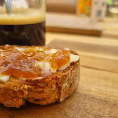 a piece of bread sitting on a wooden table with a drink at La Bulle Carrée - Centre Historique médiéval - in Lapalme