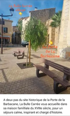 a park bench with a sign on it at La Bulle Carrée - Centre Historique médiéval - in Lapalme