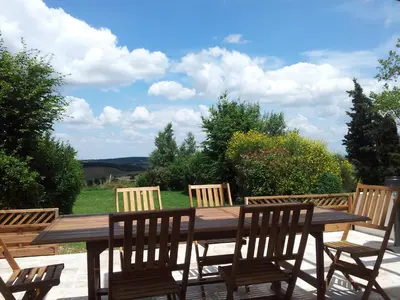 a wooden table and chairs on a patio at Fossat in Villautou