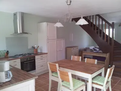 a kitchen with a dining room table and a staircase at Fossat in Villautou
