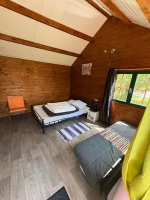 a room with two beds in a wooden cabin at Lac de Latournerie in Cazals-des-Baylès