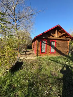 a small house on top of a grassy hill at Lac de Latournerie in Cazals-des-Baylès