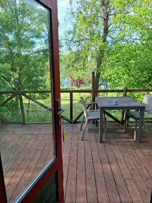 a patio with a table and a bench on a deck at Lac de Latournerie in Cazals-des-Baylès