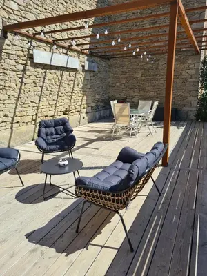 a patio with two chairs and a table on a deck at T3 de 70m2 avec sauna, piscine intérieure chauffée in Siran