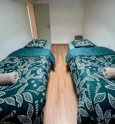two beds sitting next to each other in a room at Charmante maison de village in Pennautier