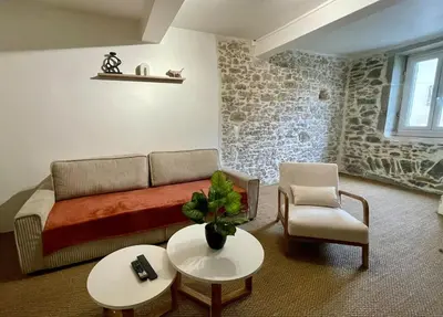 a living room with a couch and a chair at Charmante maison de village in Pennautier