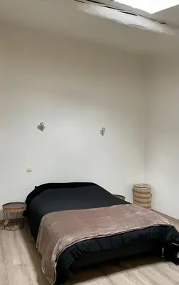 a bedroom with a bed in a white wall at Charmante maison de village in Pennautier