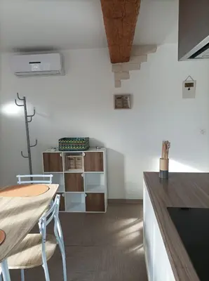 a kitchen with a counter and a table and chairs at Chez Sabine La campagne BIS in Narbonne