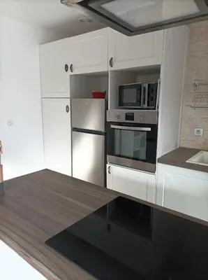 a kitchen with a stainless steel refrigerator and microwave at Chez Sabine La campagne BIS in Narbonne