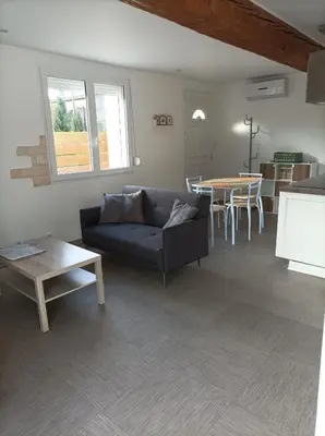a living room with a couch and a table at Chez Sabine La campagne BIS in Narbonne