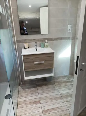 a man taking a picture of a bathroom with a sink at Chez Sabine La campagne BIS in Narbonne
