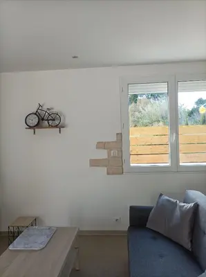 a living room with a bike on the wall at Chez Sabine La campagne BIS in Narbonne
