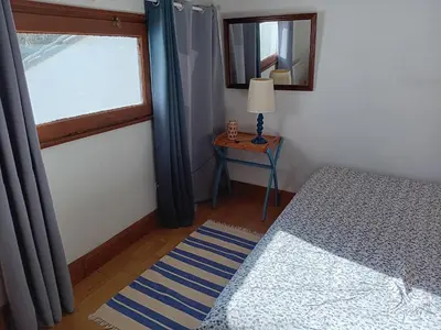 a bedroom with a bed and a table with a window at Maison de campagne avec lac privé in Fendeille