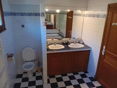 a bathroom with two sinks and a toilet at Maison de campagne avec lac privé in Fendeille